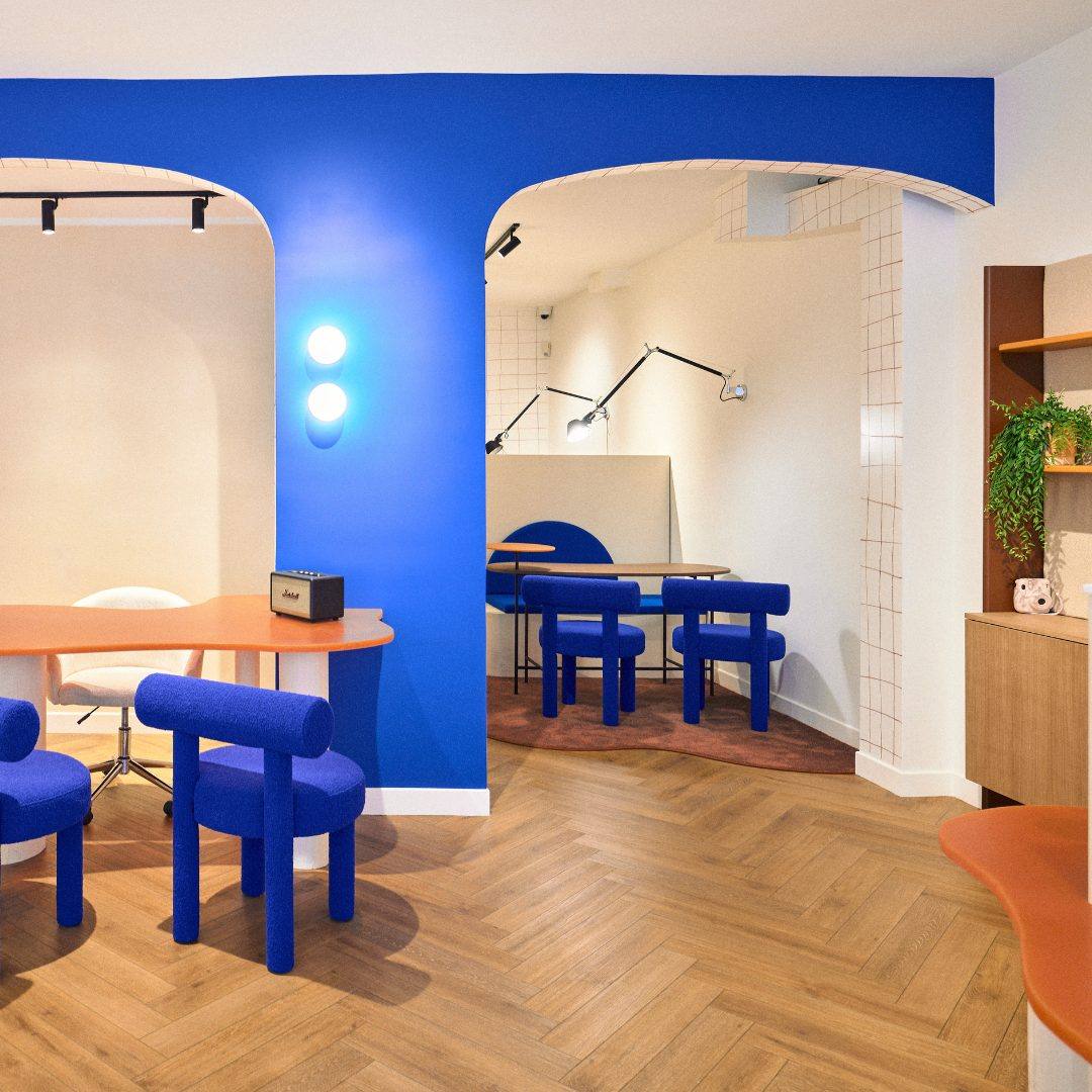 Local commercial rénové, arches bleues et parquet chevron